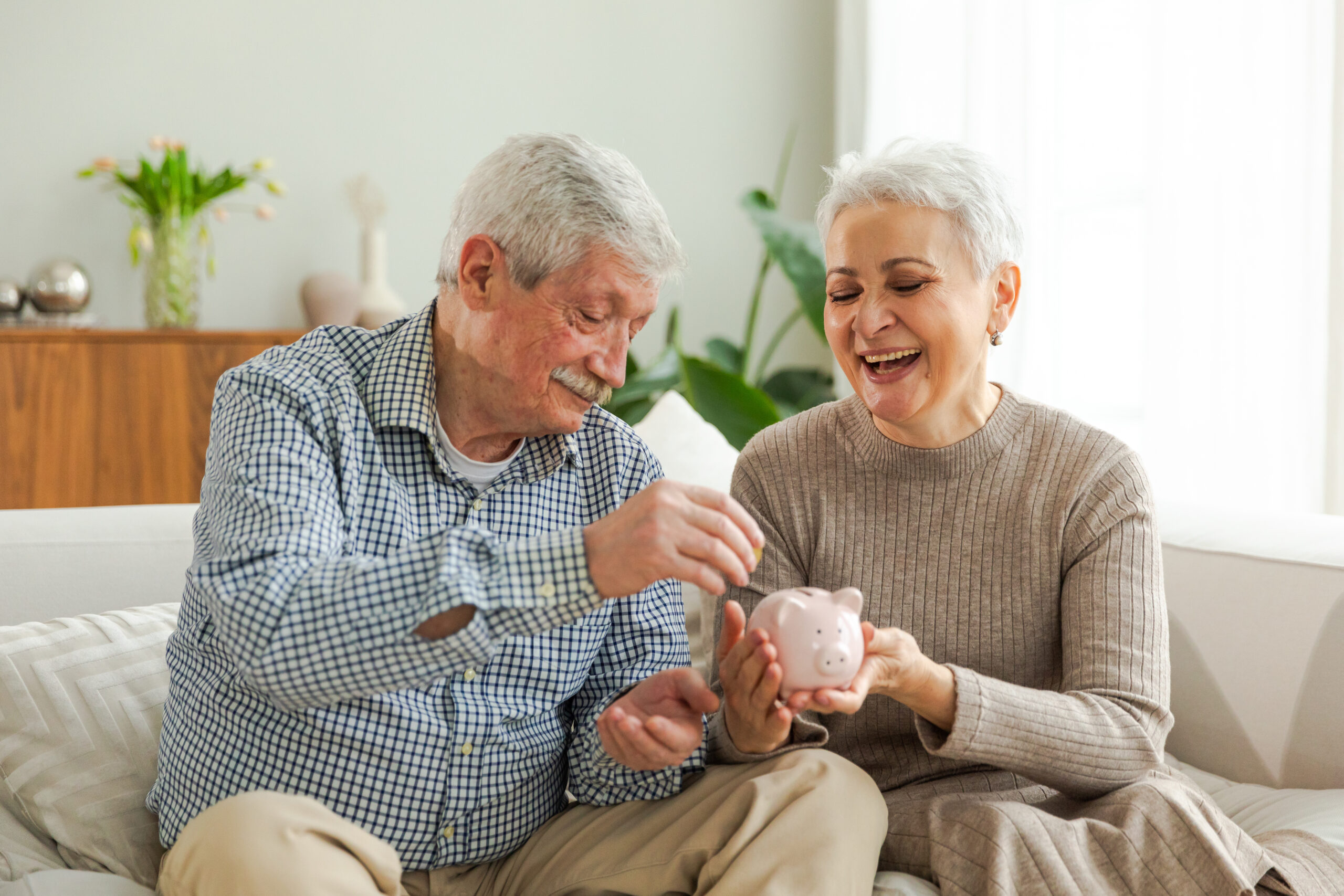 Saving money investment for future. Senior adult mature couple holding piggy bank putting money coin. Old man woman counting saving money planning retirement budget. Saving investment banking concept.